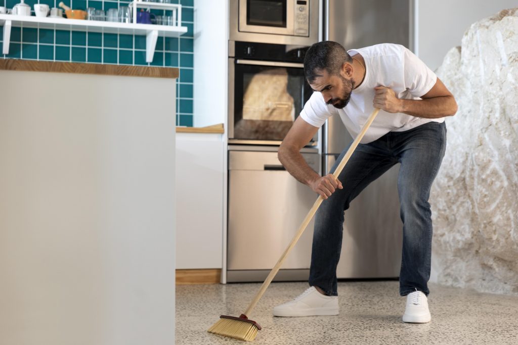Full shot man cleaning kitchen