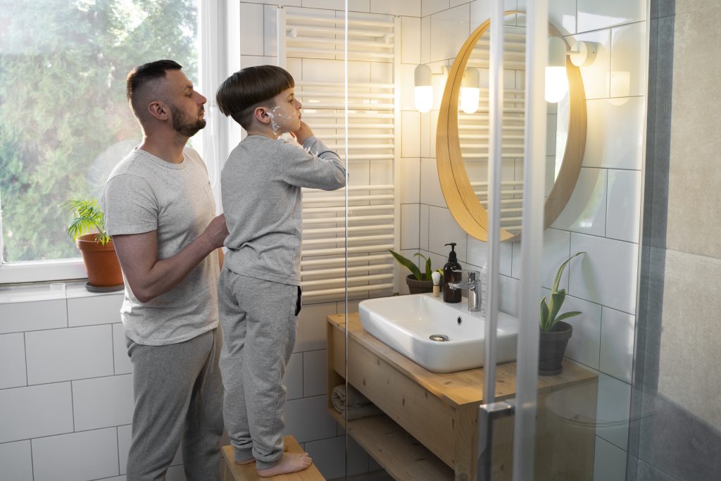 Side view kid learning shave from father