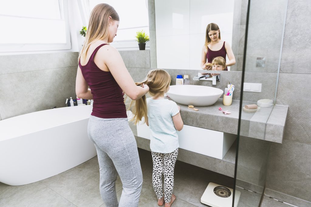 Woman braiding hair daughter