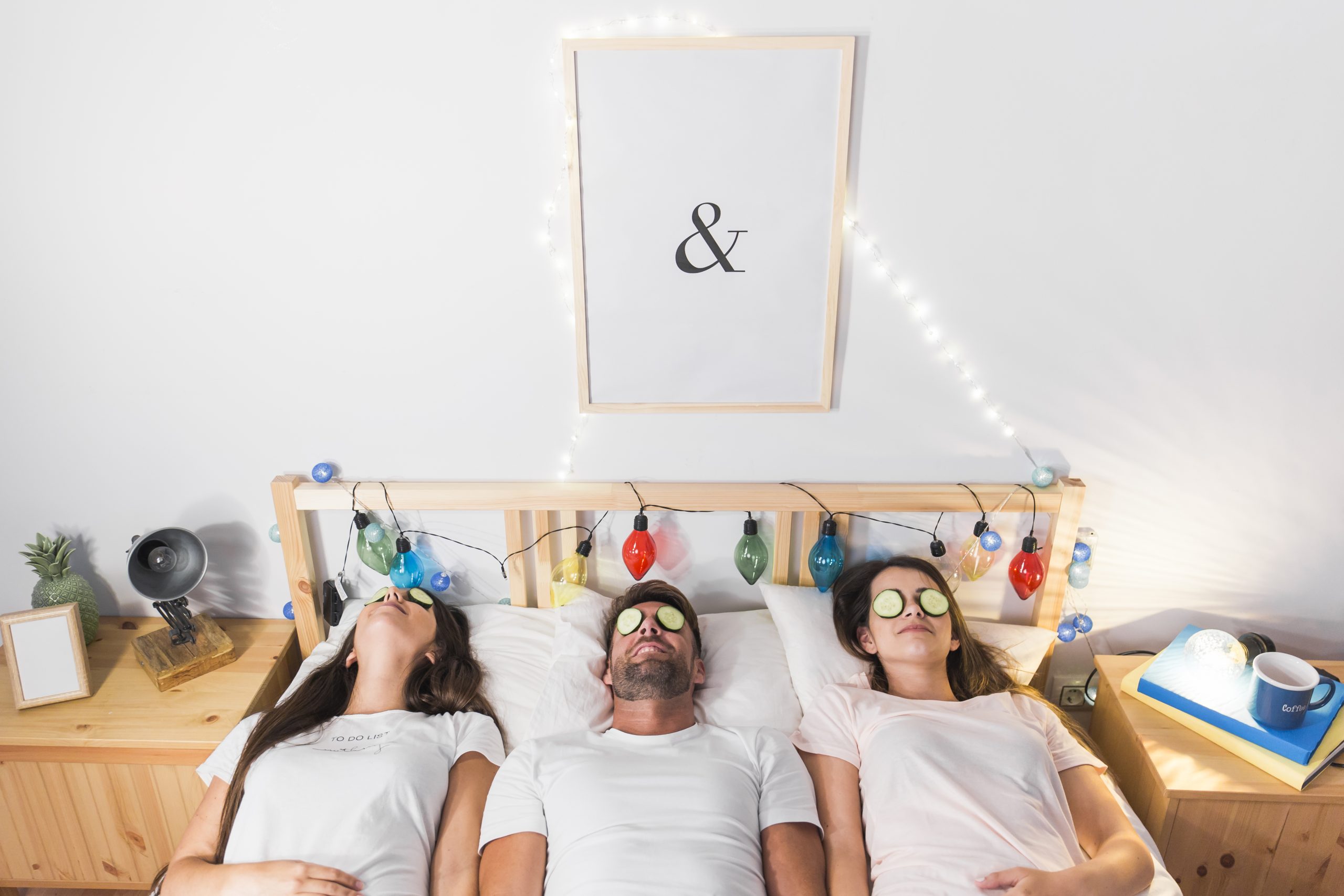 Young friends lying with cucumber slices their eyes