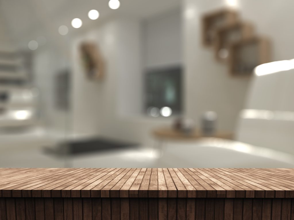 3d wooden table looking out to a defocussed room interior