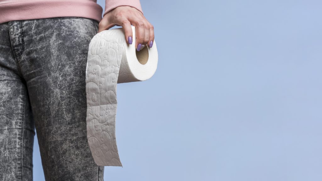 Front view person holding toilet paper roll with copy space