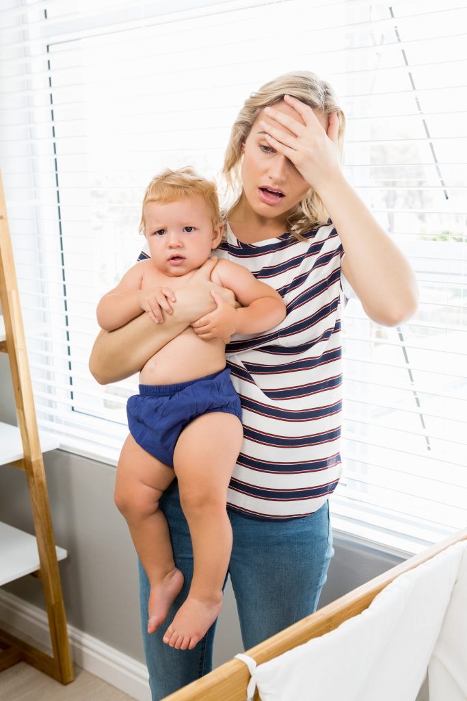 Stressed mother holding her baby boy