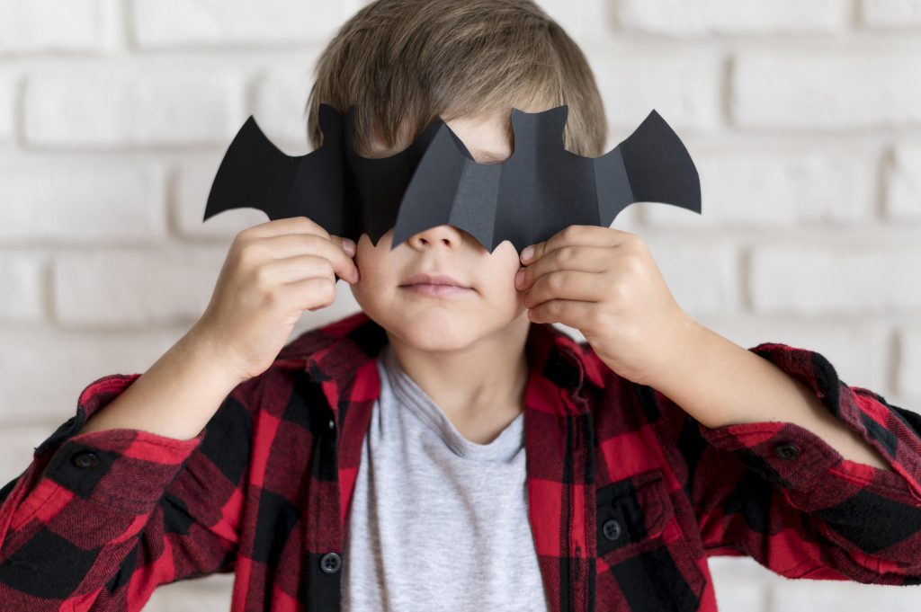 Front view boy with paper bat