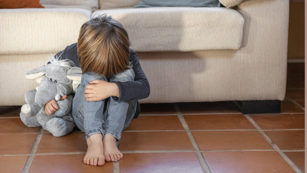 Little boy outdoors upset holding his toy