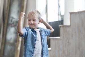Portrait smiling boy flexing his muscle