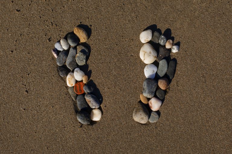 View beach sand summertime with footprints stones
